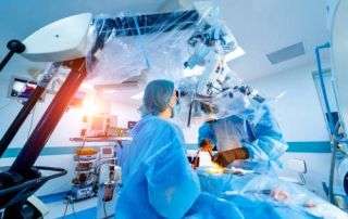 Gloved surgeon hands adjusting advanced spine surgery instrumentation, representing precision and modern spine surgery expertise.